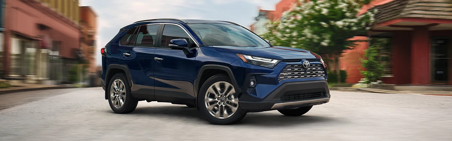 blue 2025 Toyota RAV4 driving in the city