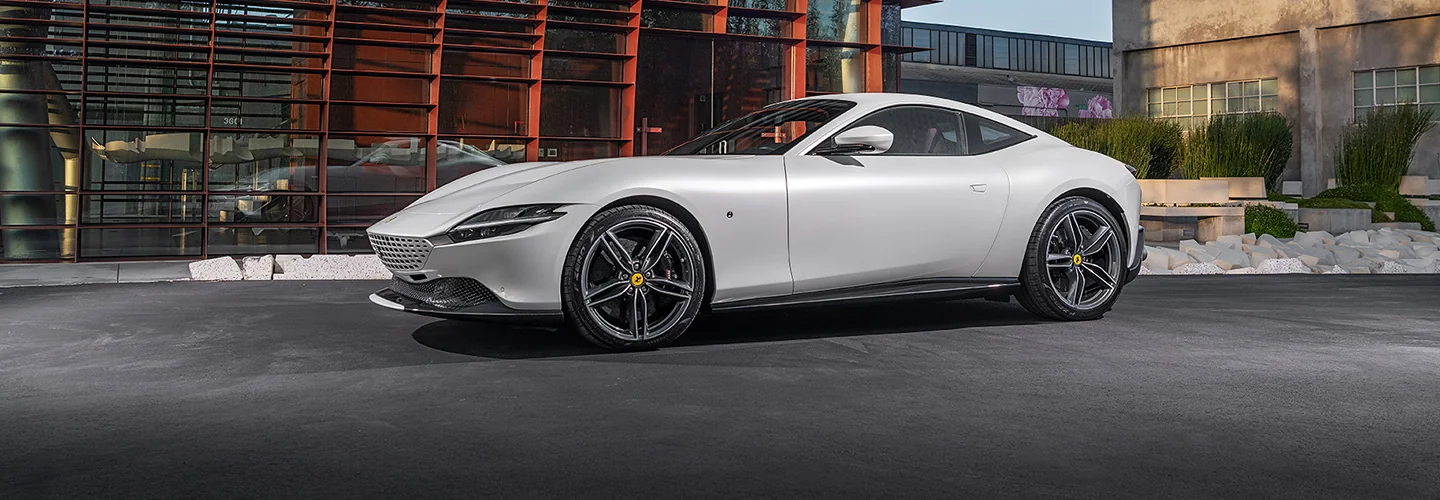 A white Ferrari parked in front of city buildings