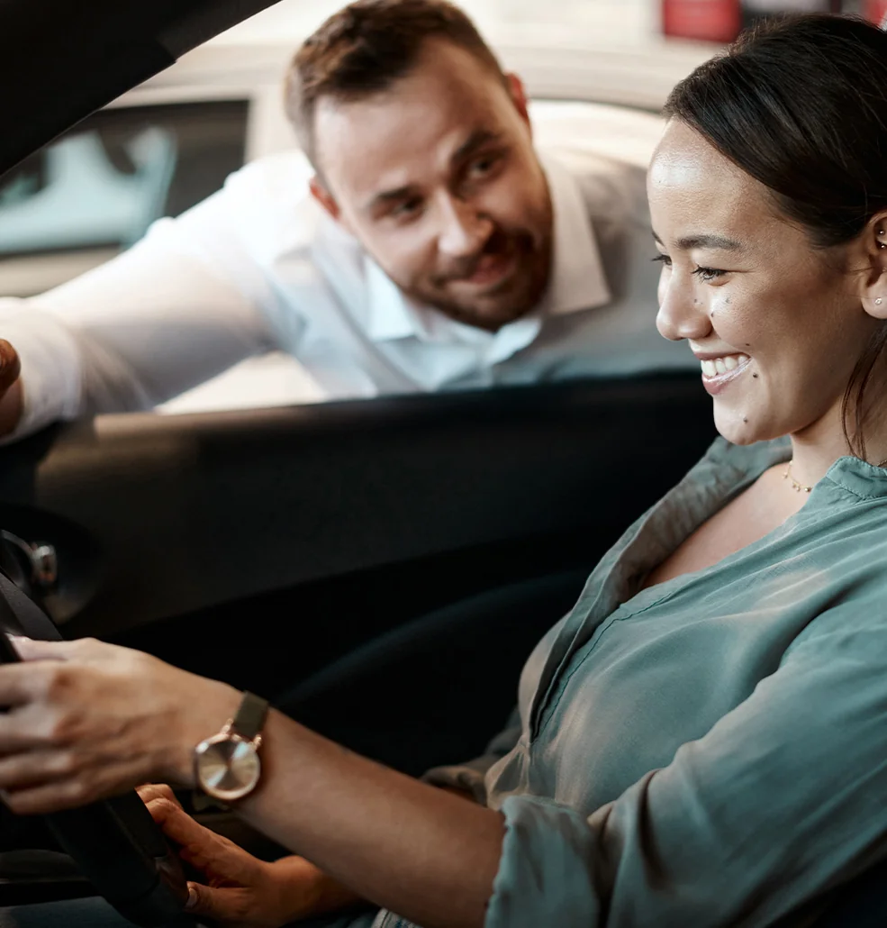 Sales person talking to customer in a car about it