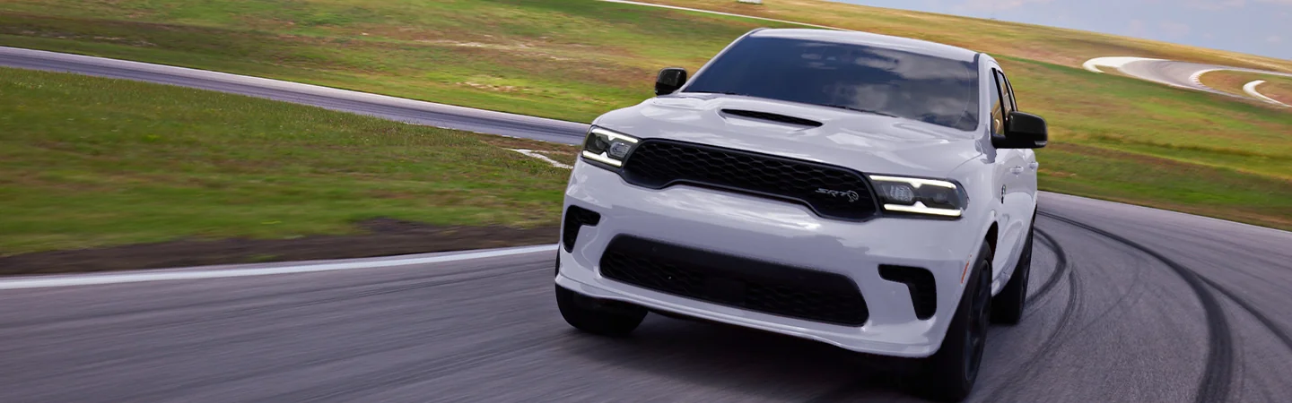 Front view of a white 2025 Dodge Durango driving on a road