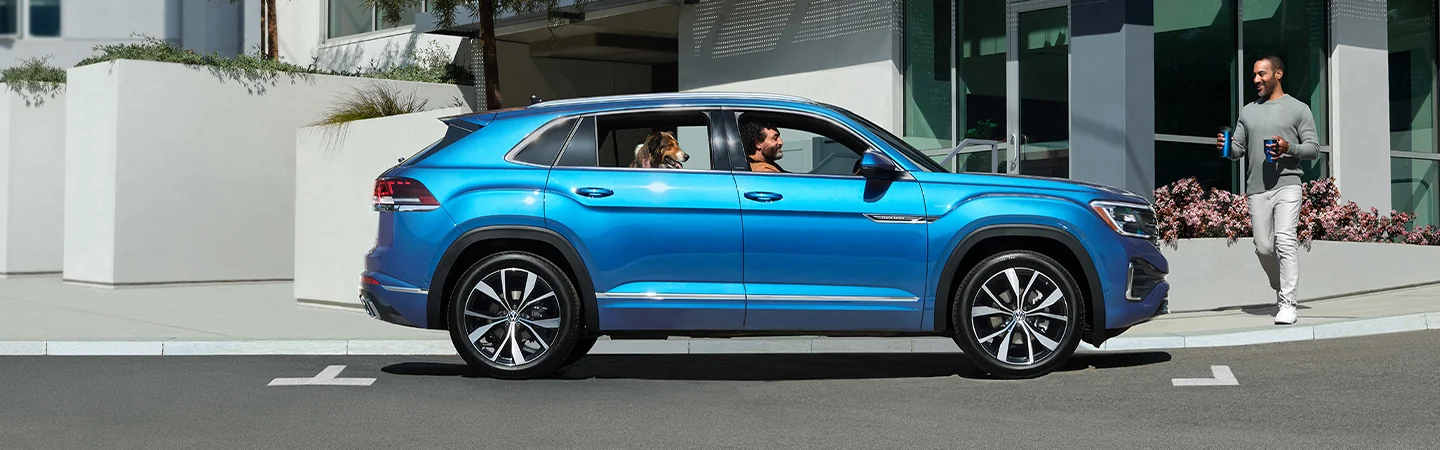 parked in the city with dog in back 2025 Volkswagen Atlas Cross Sport SE