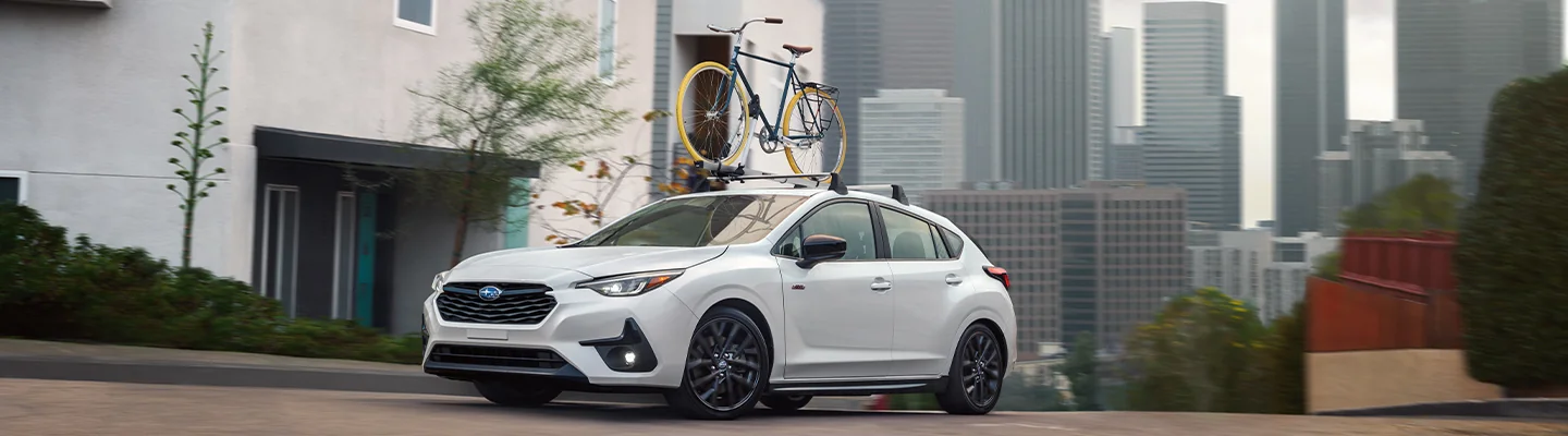 white Subaru Impreza with bike racked on top