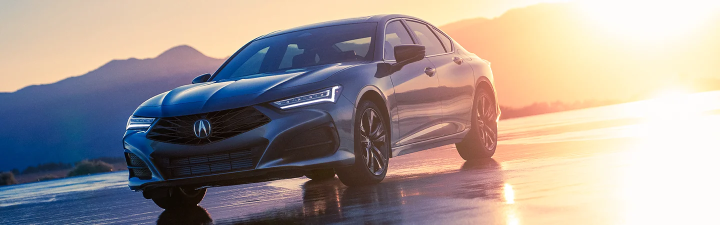 2025 Acura TLX gery car reflecting golden sunset with wet pavement with side view