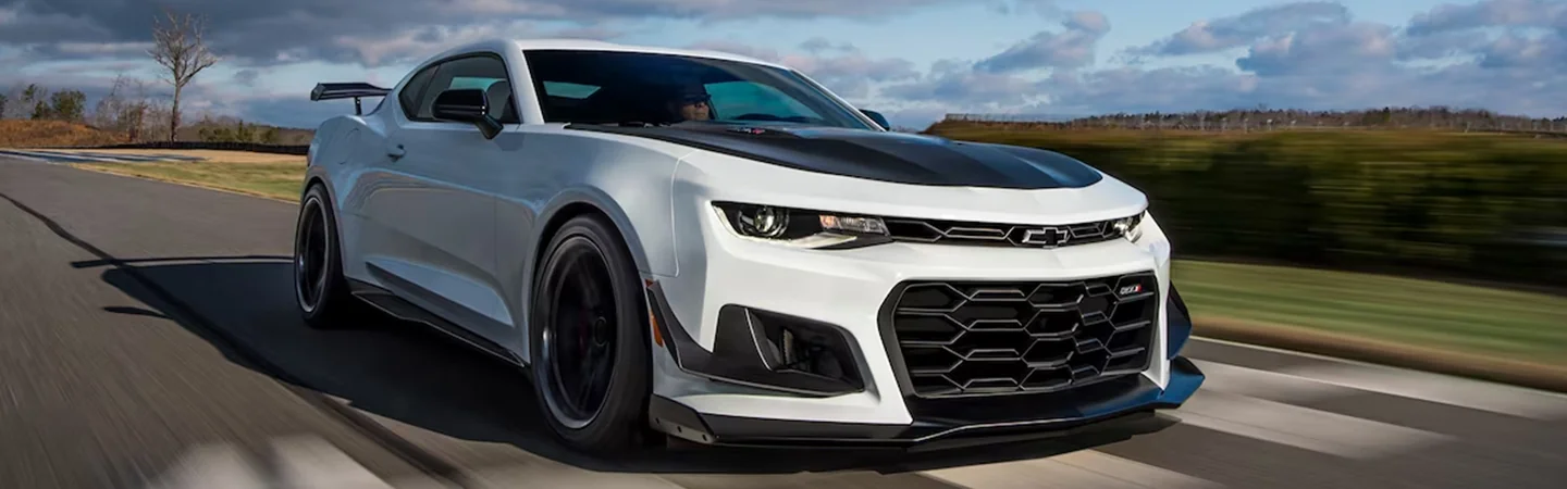Close up of a white 2024 Chevrolet Camaro driving on a road