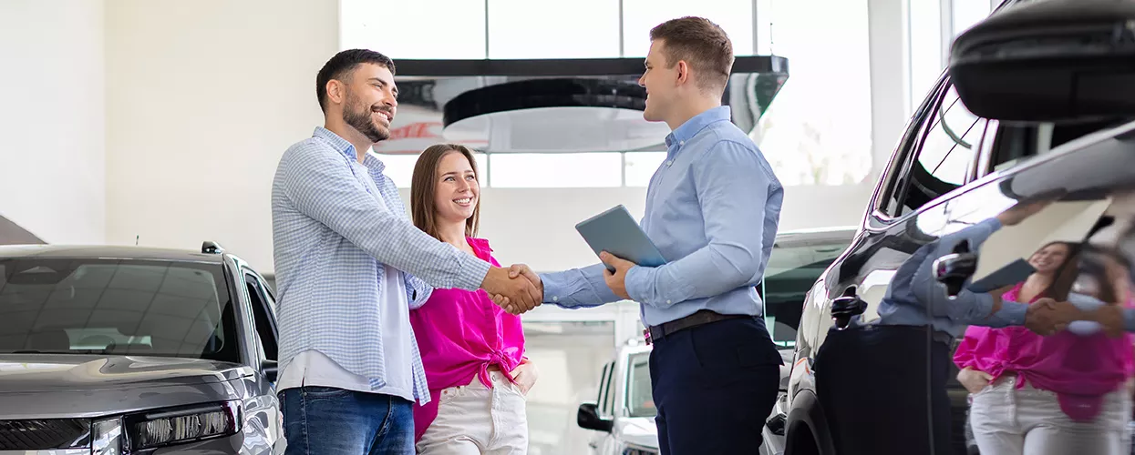 Car salesman talking to a couple about a new vehicle