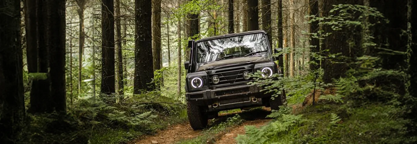 INEOS Grenadier SUV driving though a forest
