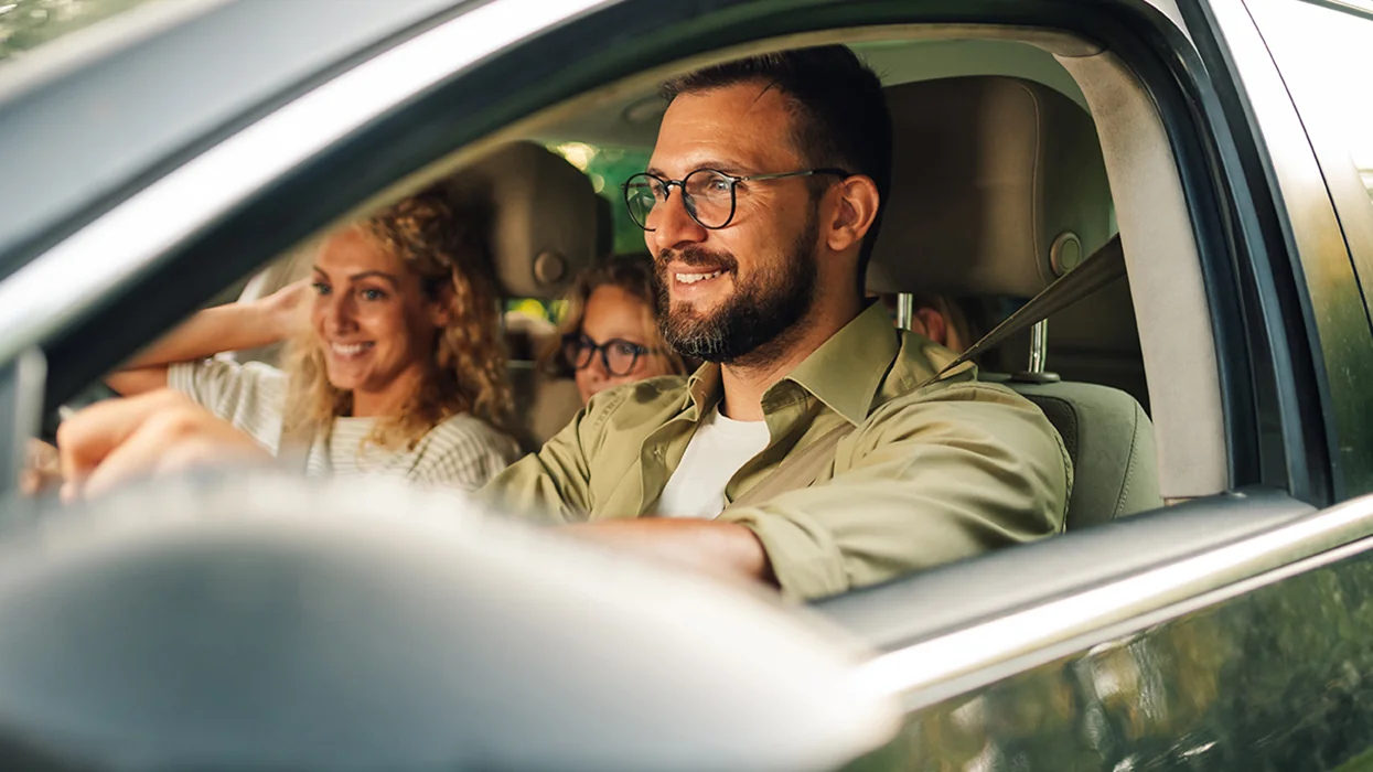 a family smiling in a car driving off after purchase