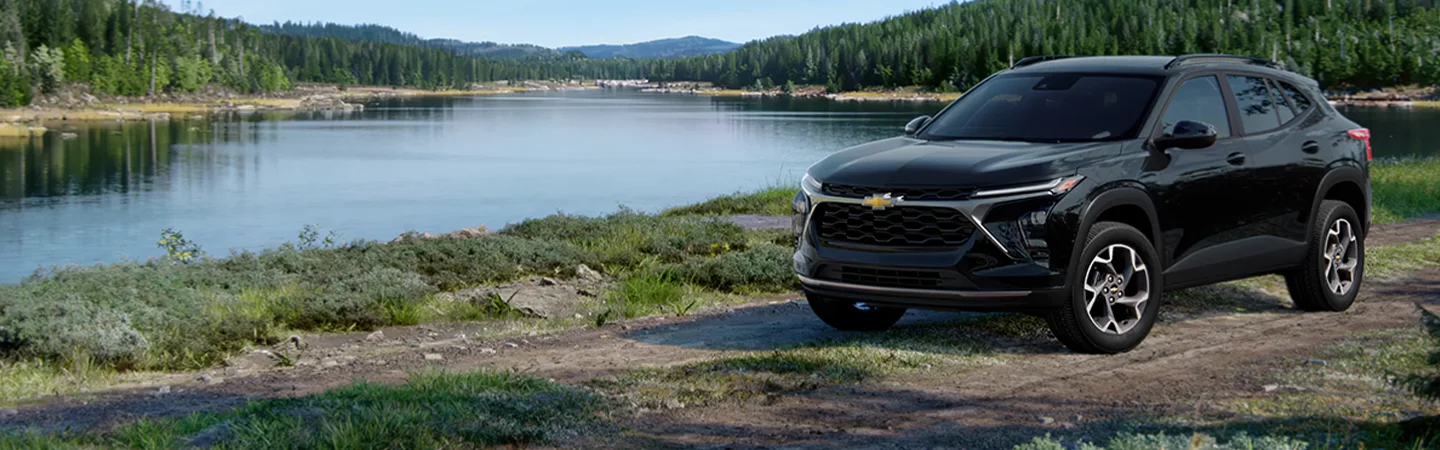 Black 2025 Chevrolet Trax parked next to a lake