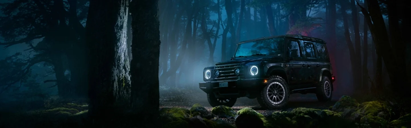 A 2025 INEOS Grenadier Trialmaster parked in the middle of the woods.