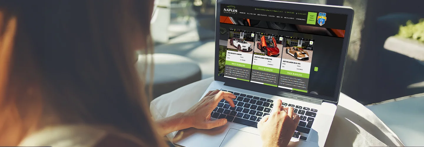 a person on a laptop shopping online at Bentley and McLaren Models in Naples, FL website