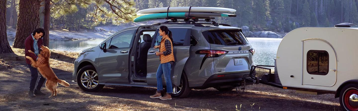 A 2022 Toyota Sienna parked by a lake getting ready to camp