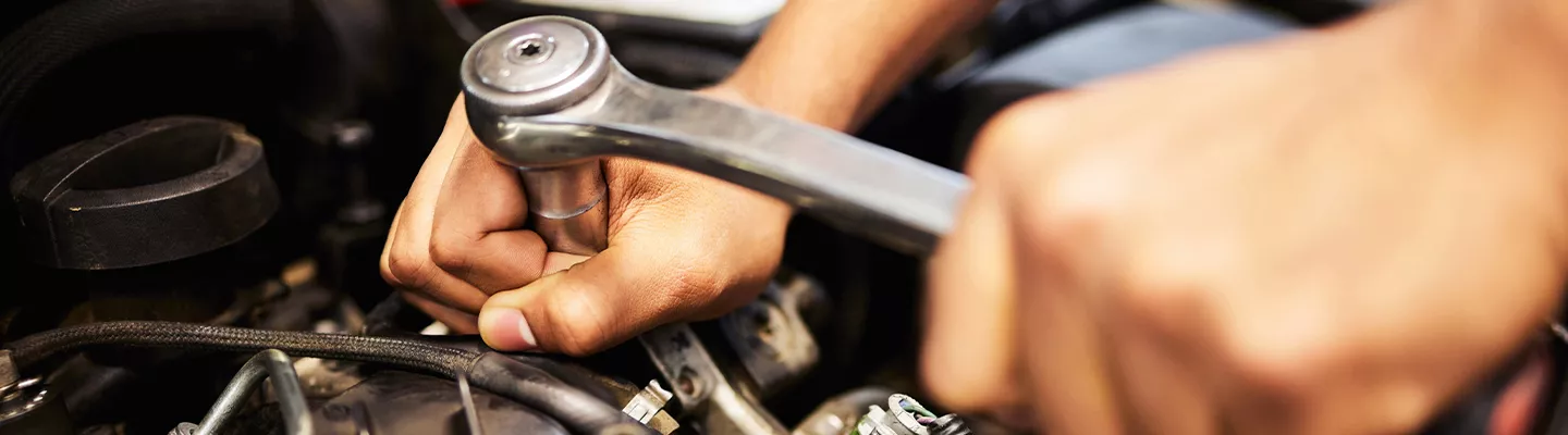 Mechanic working on a car under the hood