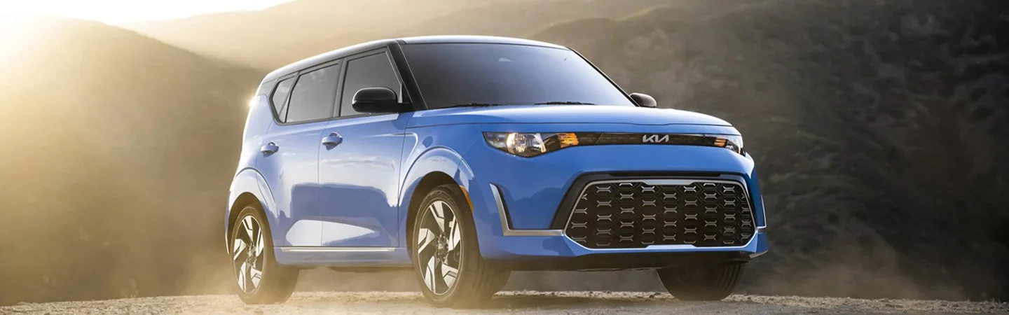 Front side view of a parked blue 2025 Kia Soul with mountain in the background