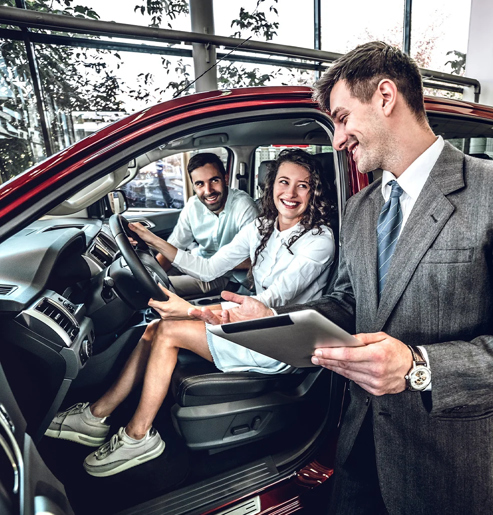 Sales person showing customers the inside of e new Ford SUV