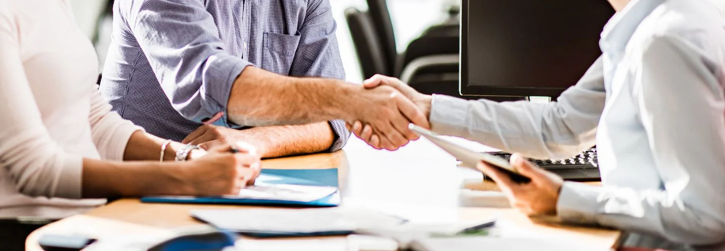 Sales person shaking hands with customers