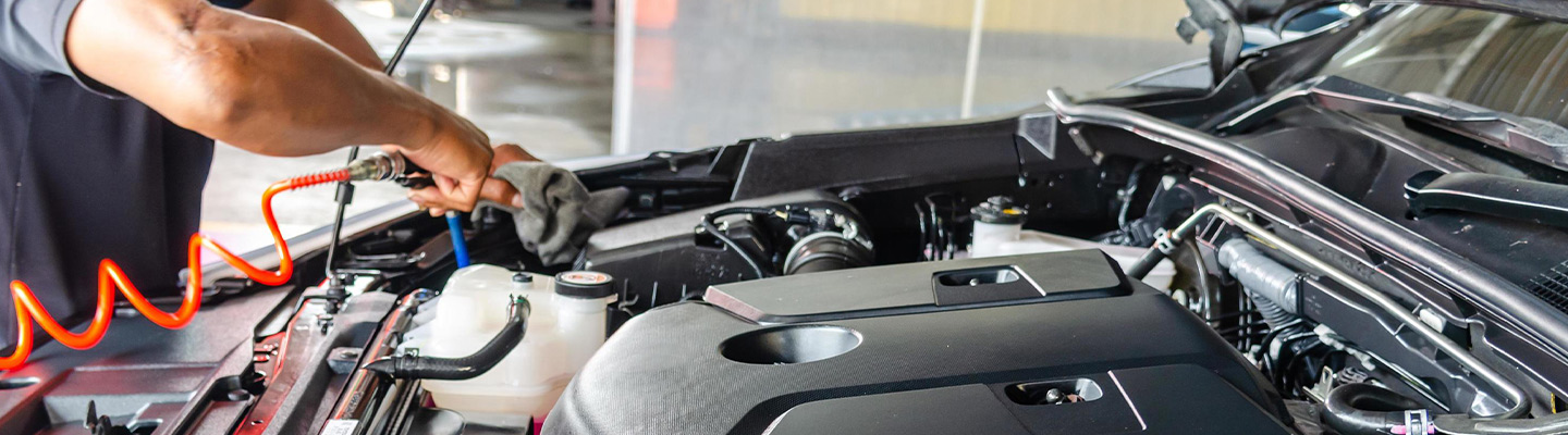 Close up view of a service technician working on an engine