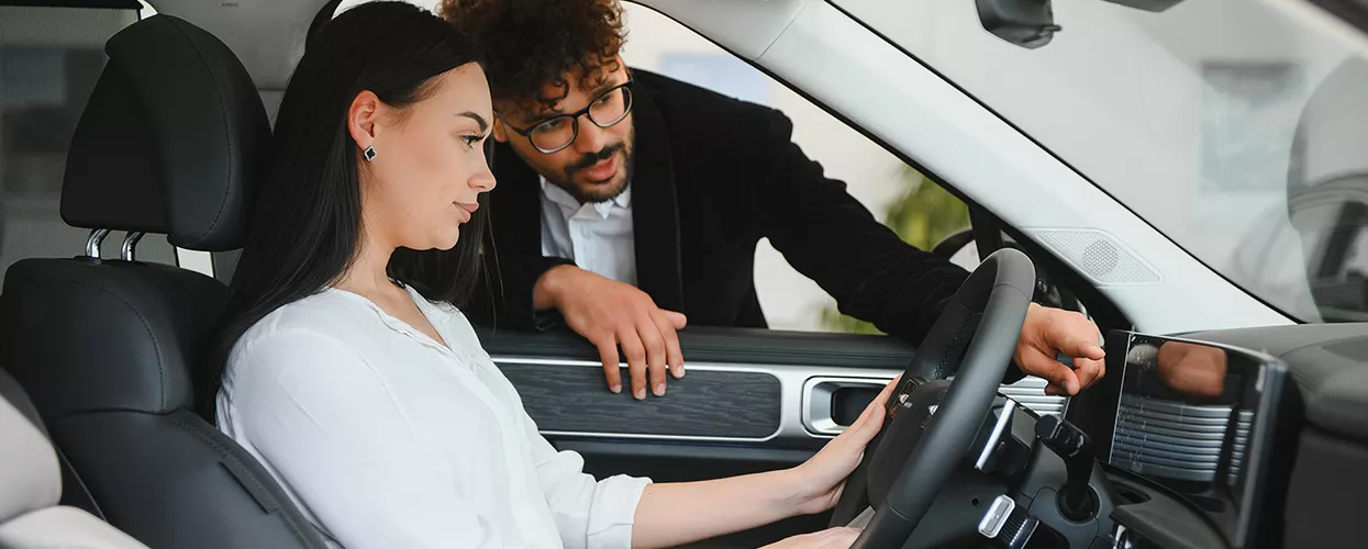 Sales person showing the inside of a new Jaguar