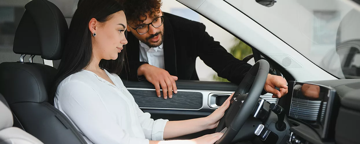 Sales person showing a women the inside of a new Land Rover
