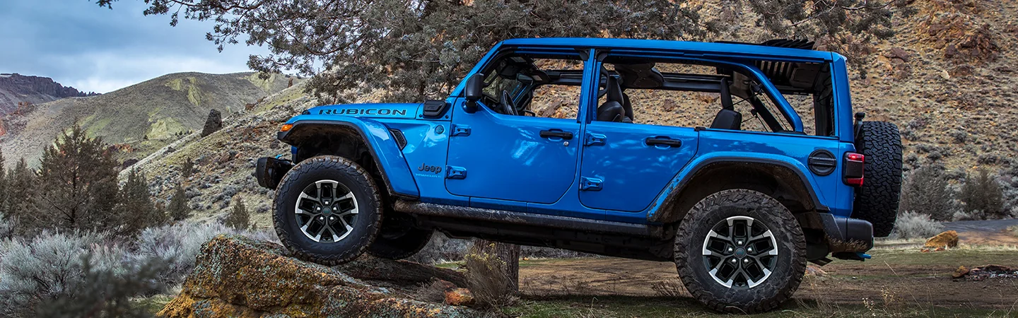 driver side view of a blue 2025 Jeep Wrangler Sport