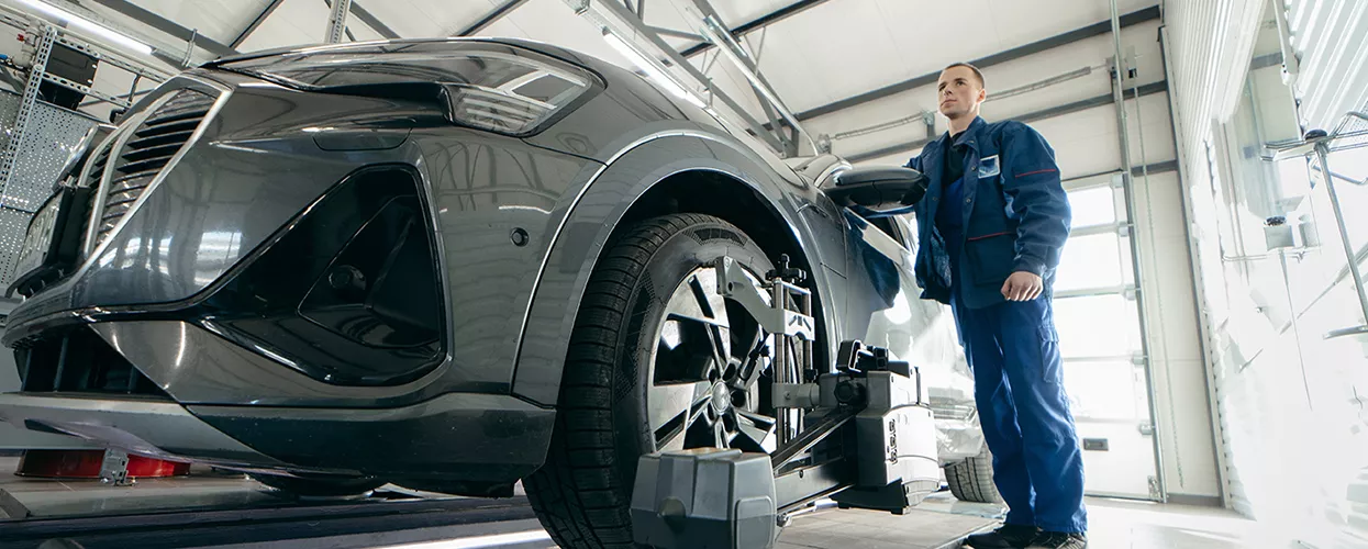 Service mechanic standing next to a vehicle