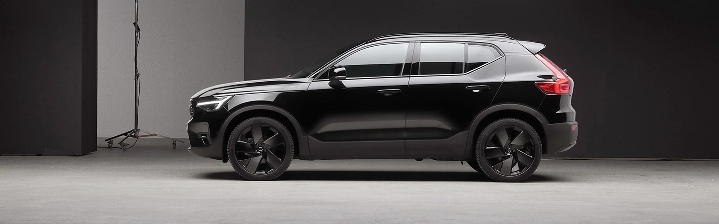 Side view of a parked black 2025 Volvo XC40 in a studio