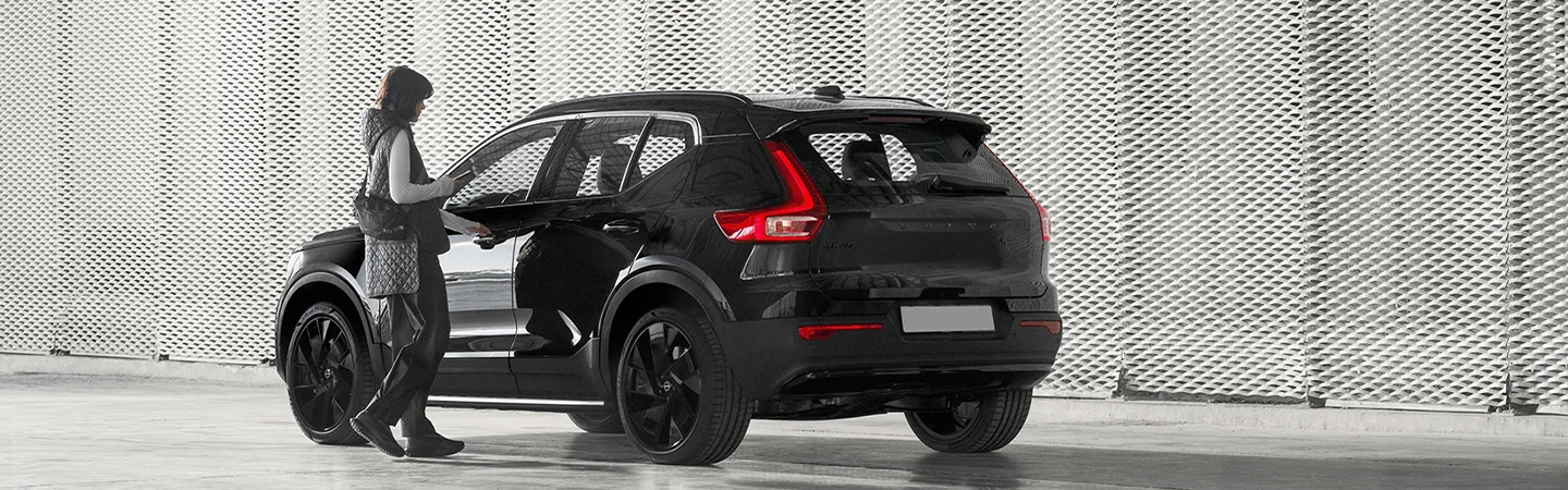 Women walking to her parked 2025 Volvo XC40 on the street
