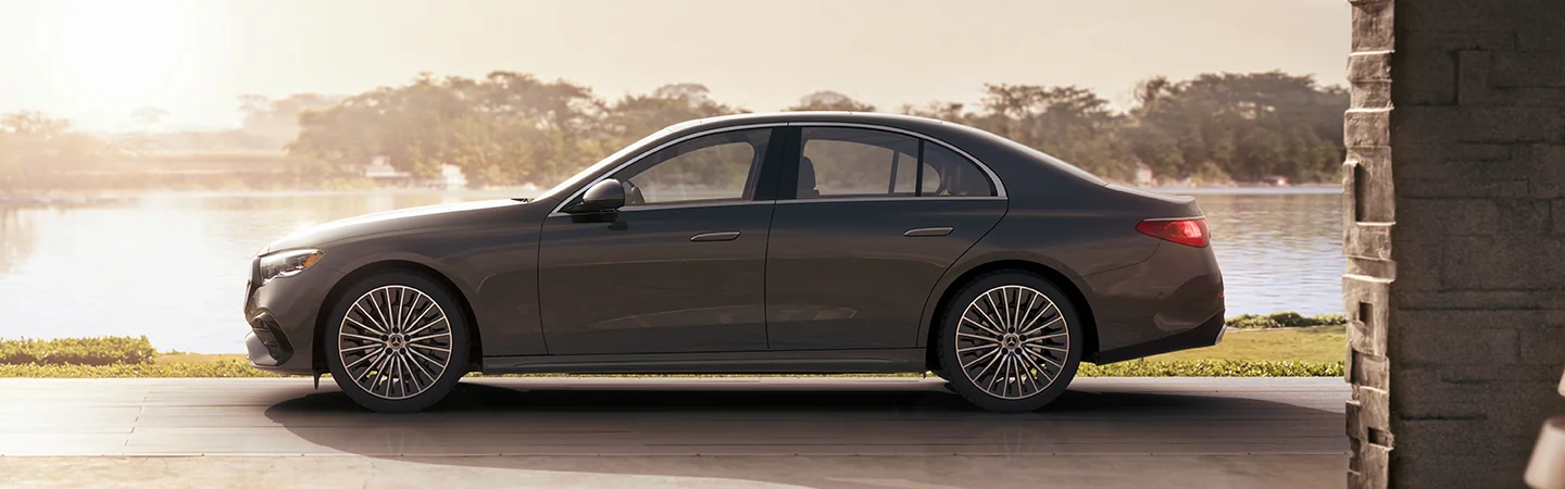 Side view of a gray 2025 Mercedes-Benz E-Class parked by a lake