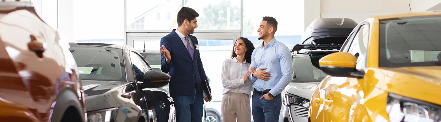 Sales person helping customer buy a used car