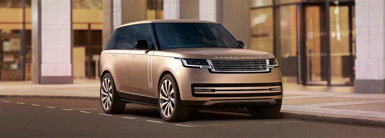 front view of a gold Range Rover parked downtown