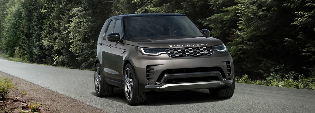 front view of a silver 2026 Discovery in motion on counrty road