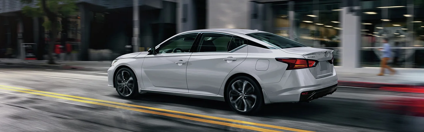 driver side view of 2025 Nissan Altima S driving in the city