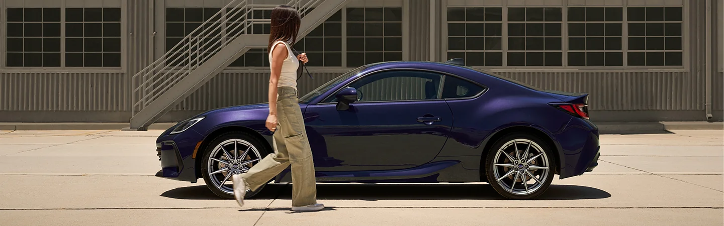 Side view of A parked purple 2025 Subaru BRZ next to a wearhouse with a person walking to the car in Chattanooga, TN.