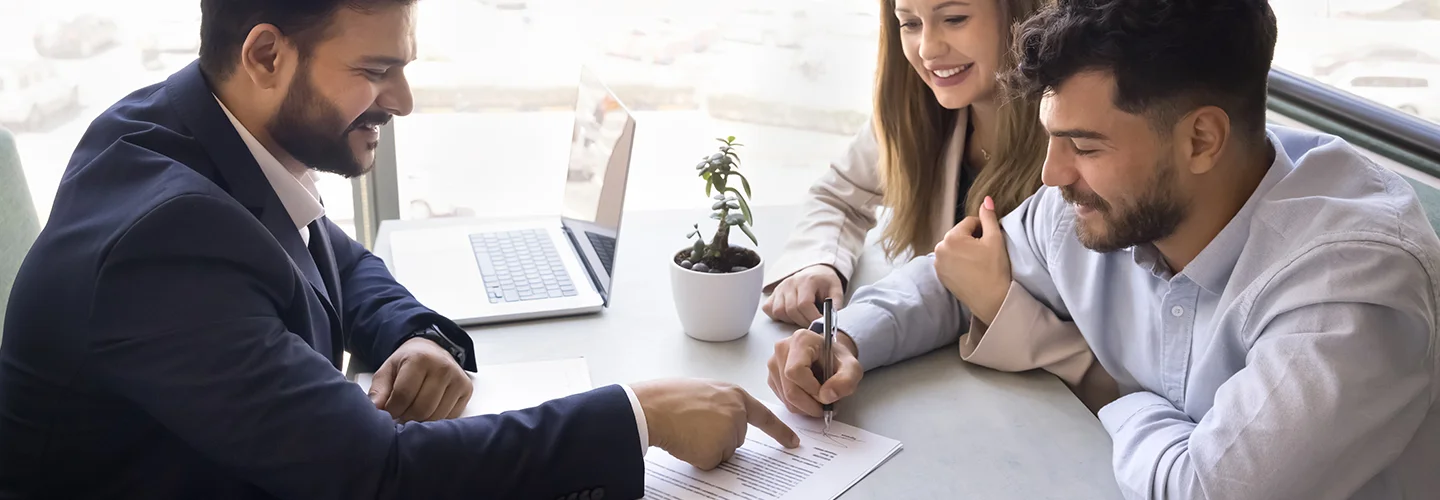 young couple signing a document