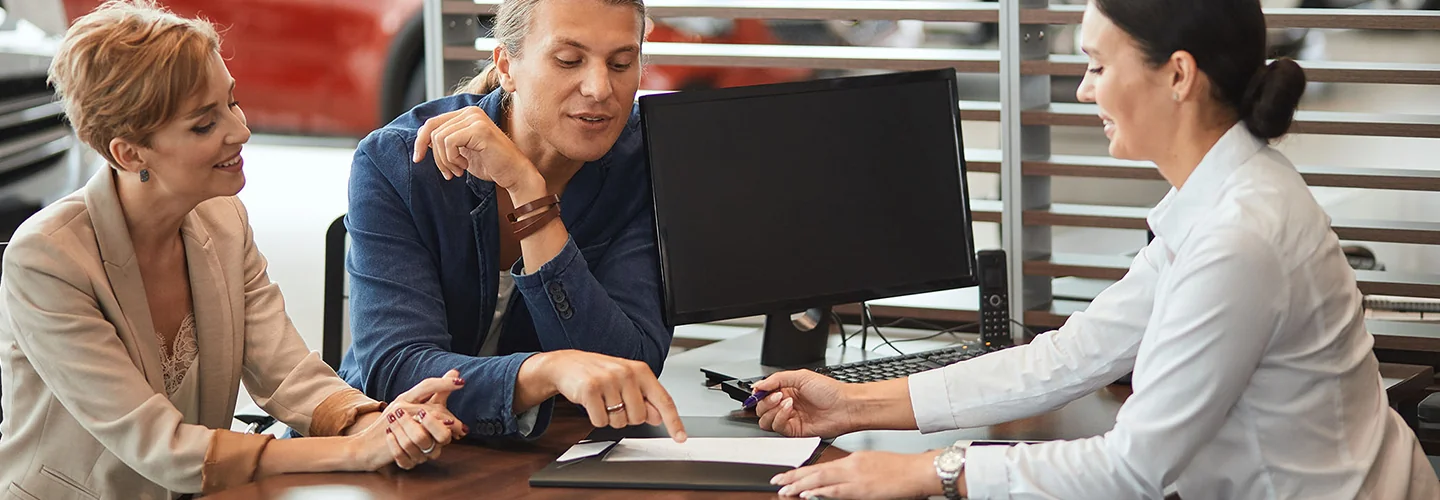 Couple discussing car sales with sales person