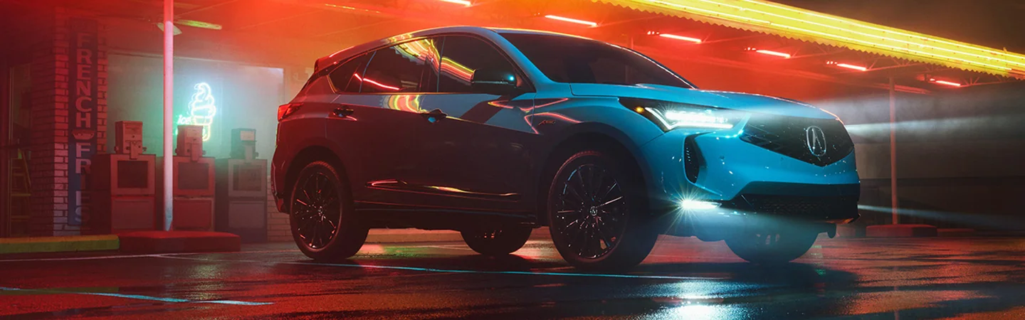 Parked 2025 Acura RDX in front of a store with lots of neon