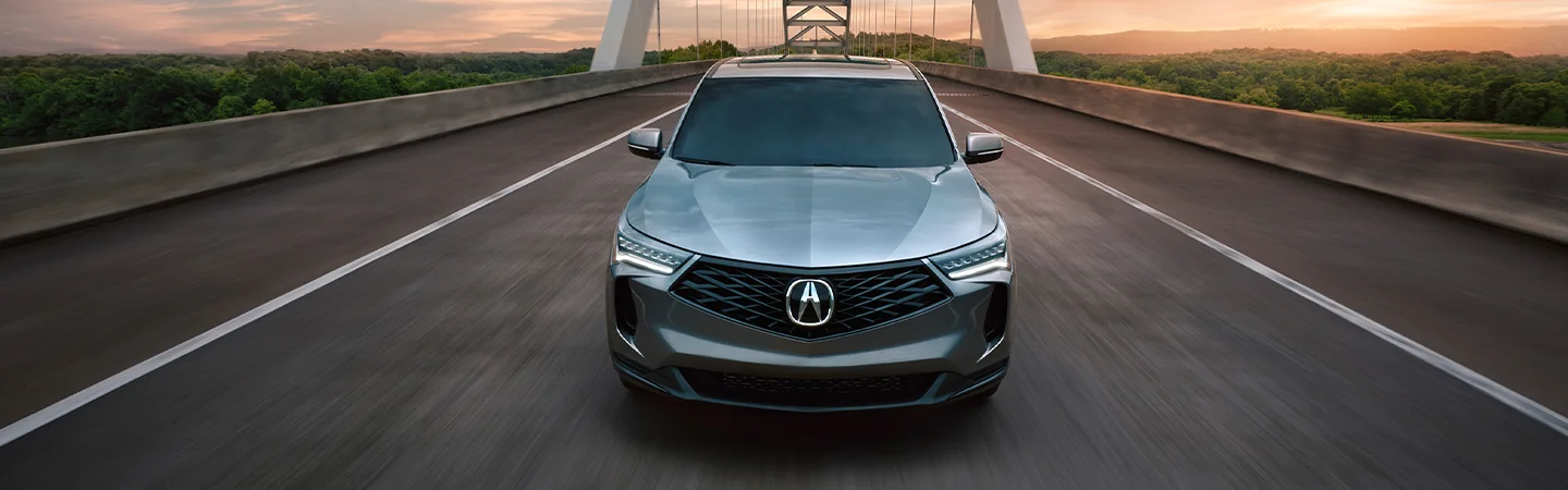 Front view of a 2025 Acura RDX driving over a bridge