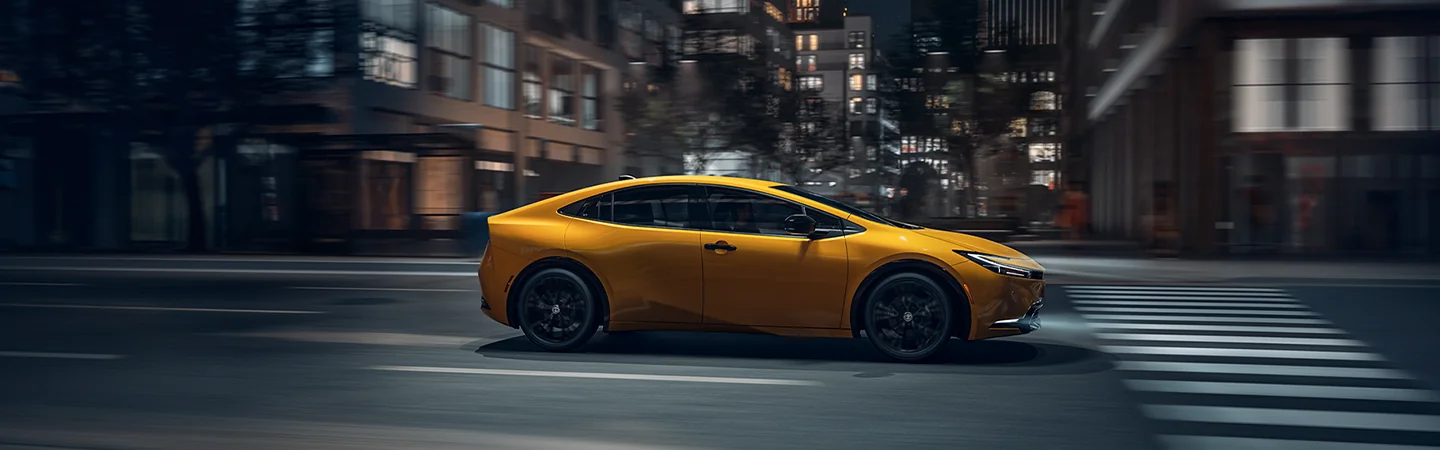 driving side view of a 2025 Toyota Prius LE in motion