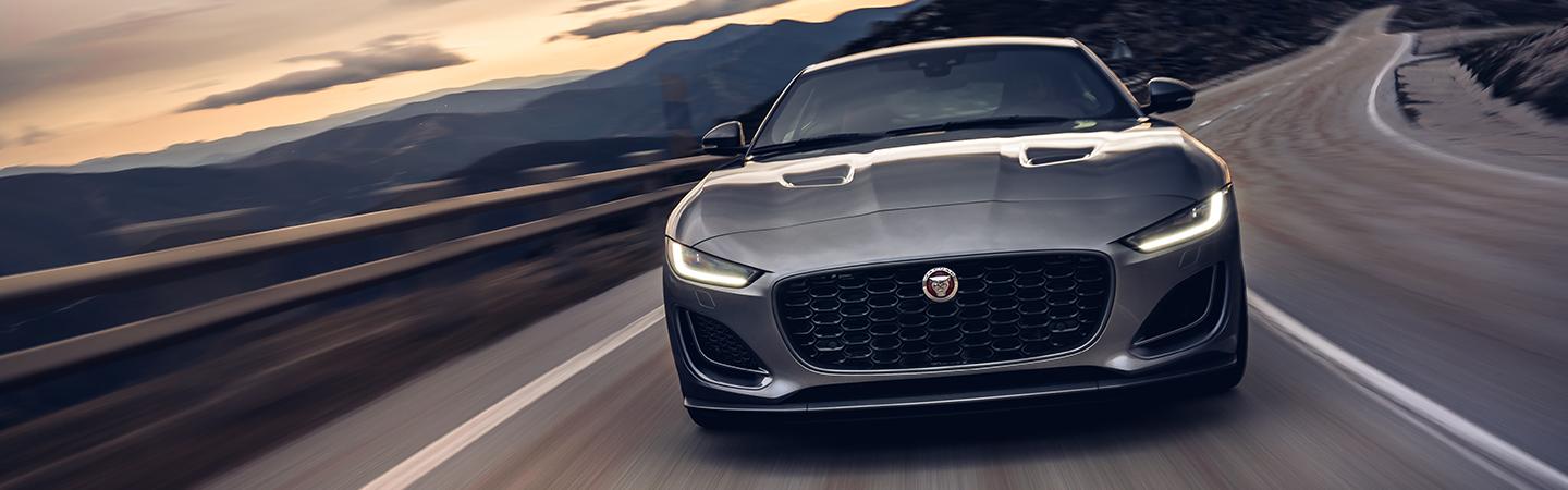 Gray 2022 Jaguar F-TYPE front view in motion drivng on mountian road