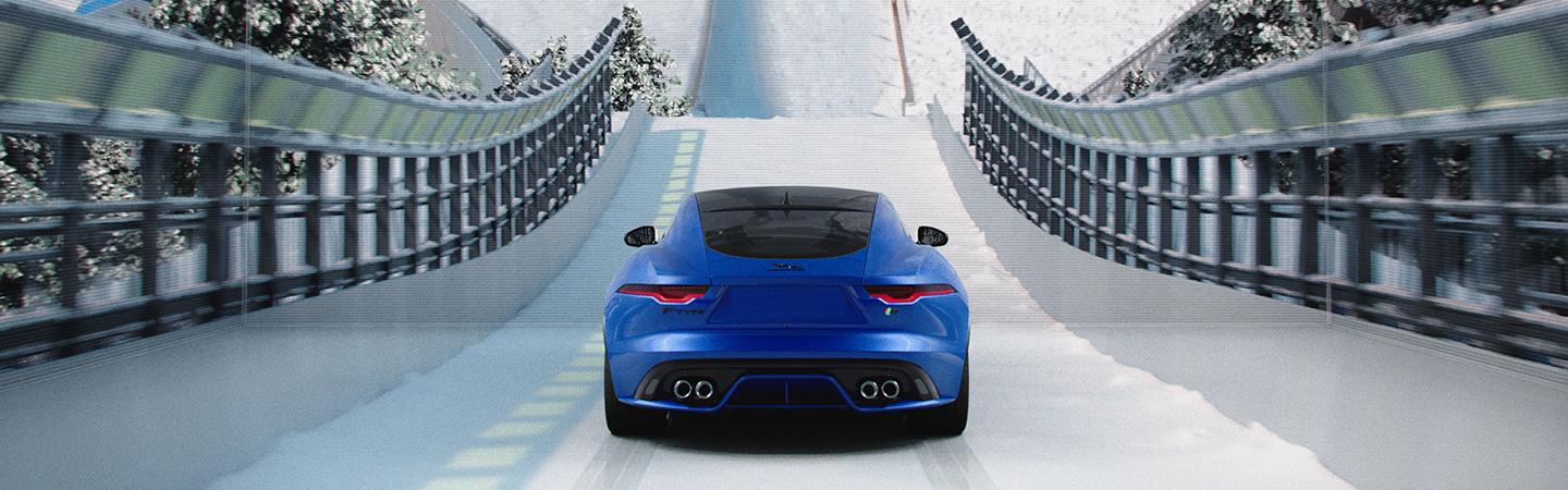 Blue 2022 Jaguar F-TYPE rear view about to jump off ski jump