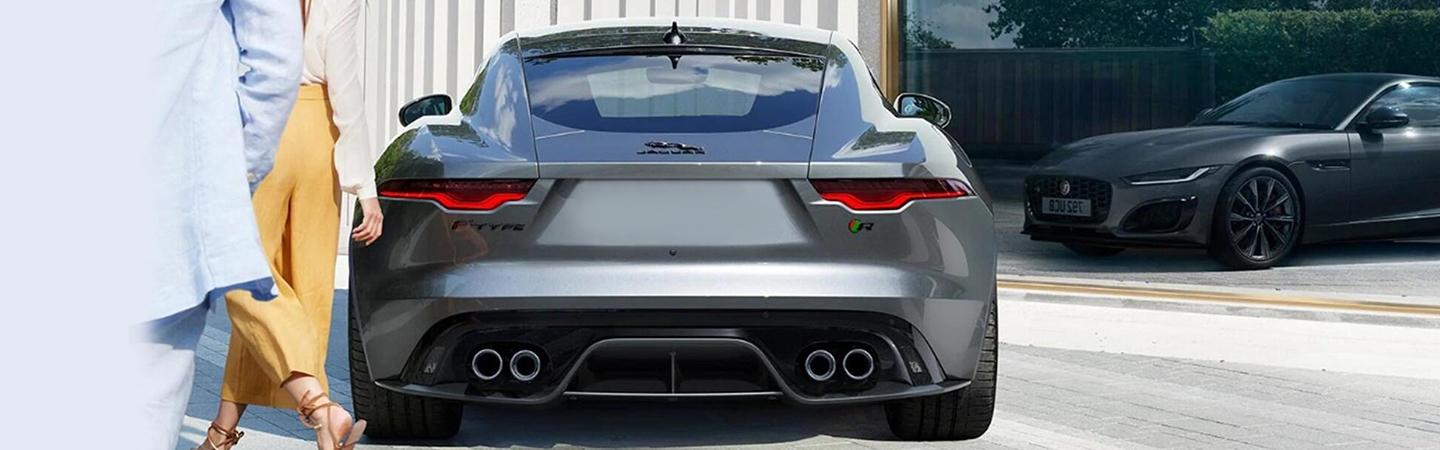 Gray 2022 Jaguar F-TYPE rear view parked with someone walking up