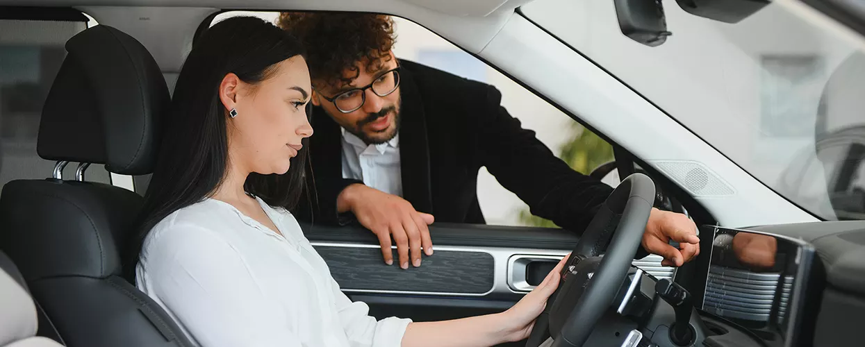 Car salesman talking to a customer about a new vehicle