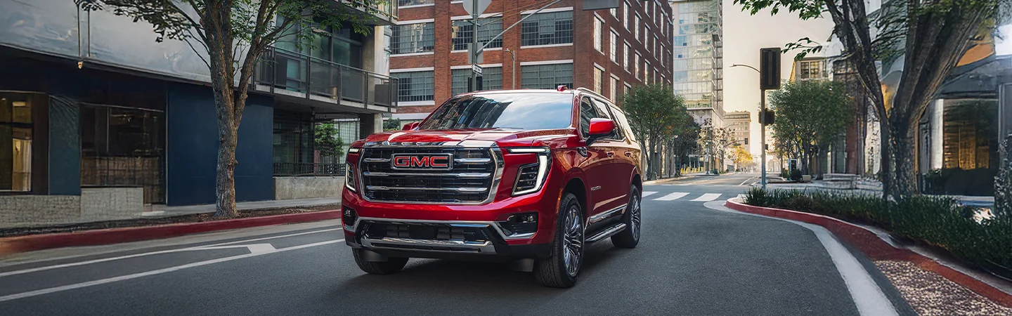 front view of a 2025 GMC Yukon driving on city street