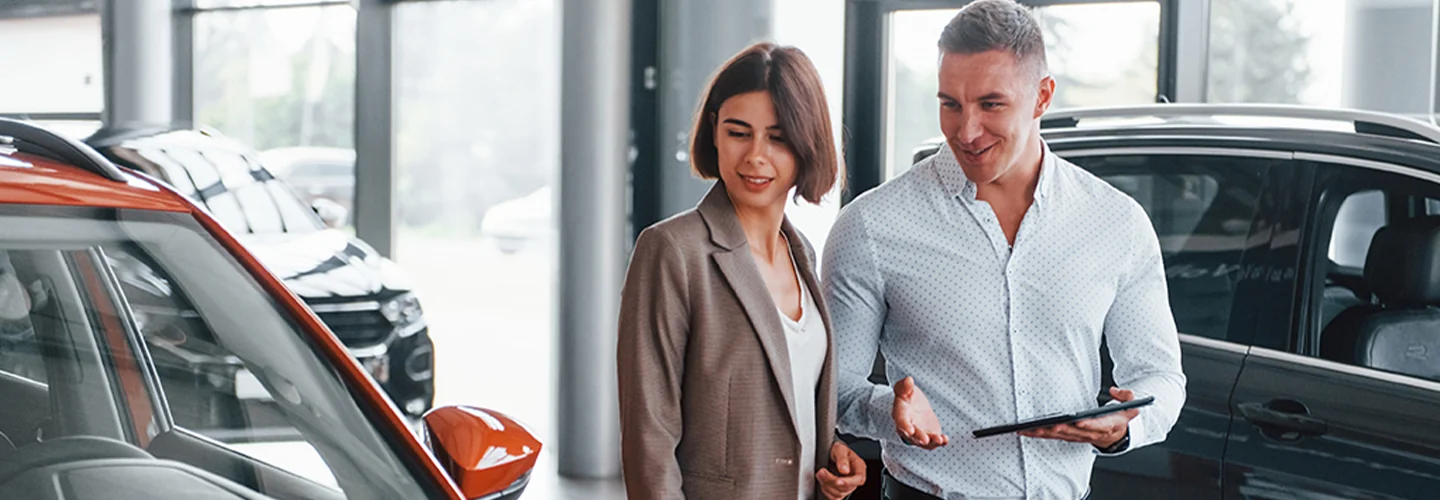 Sales person showing customer new cars