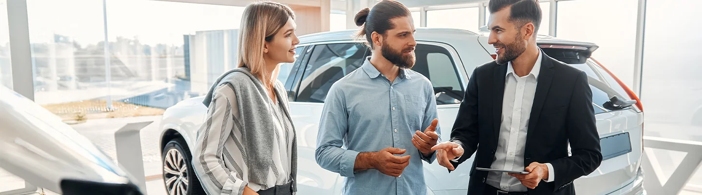 Car salesman speaking with customers