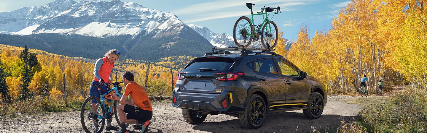 2025 Subaru Crosstrek Wilderness unloading bikes for a gravel road ride with scenic mountain in distant view