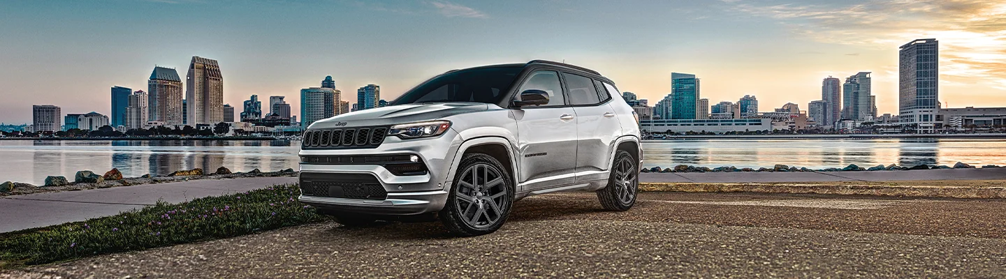 Jeep Compass parked in front of a city skyline