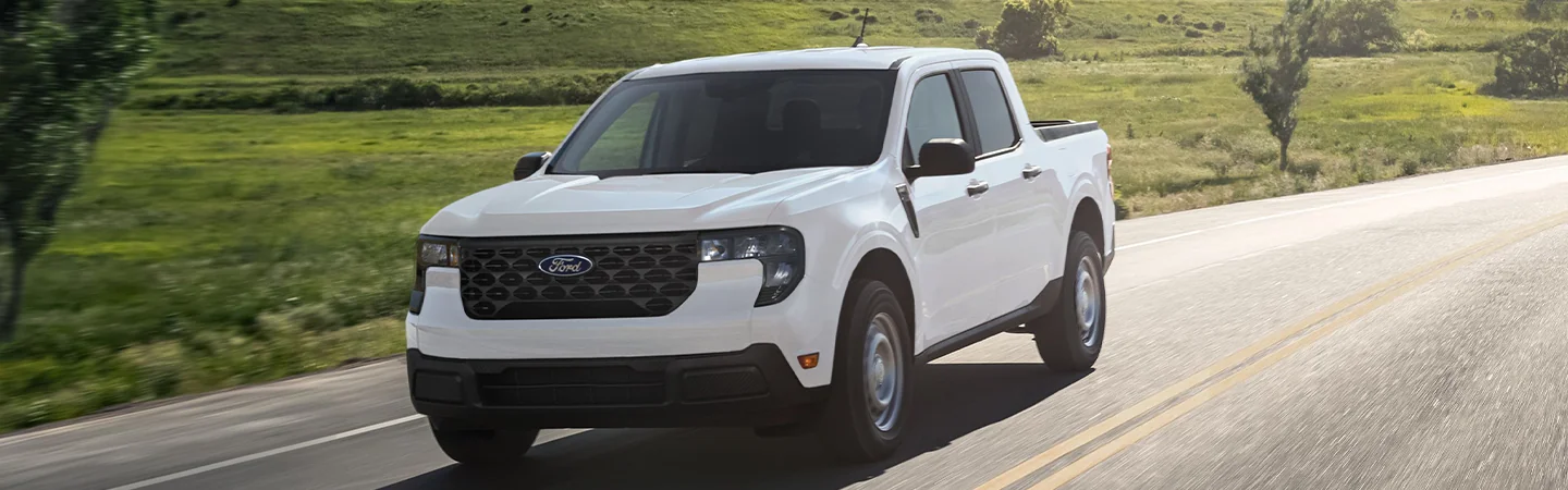 a white 2025 Ford Maverick driving on a road