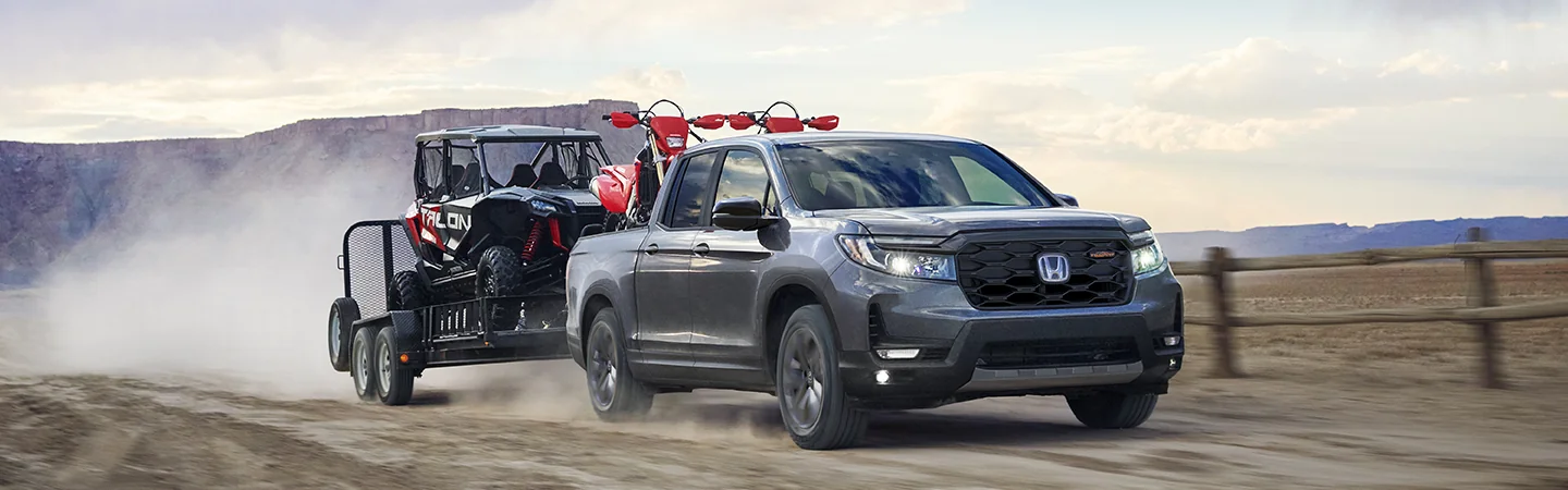 Gray 2025 Honda Ridgeline towing ATVs