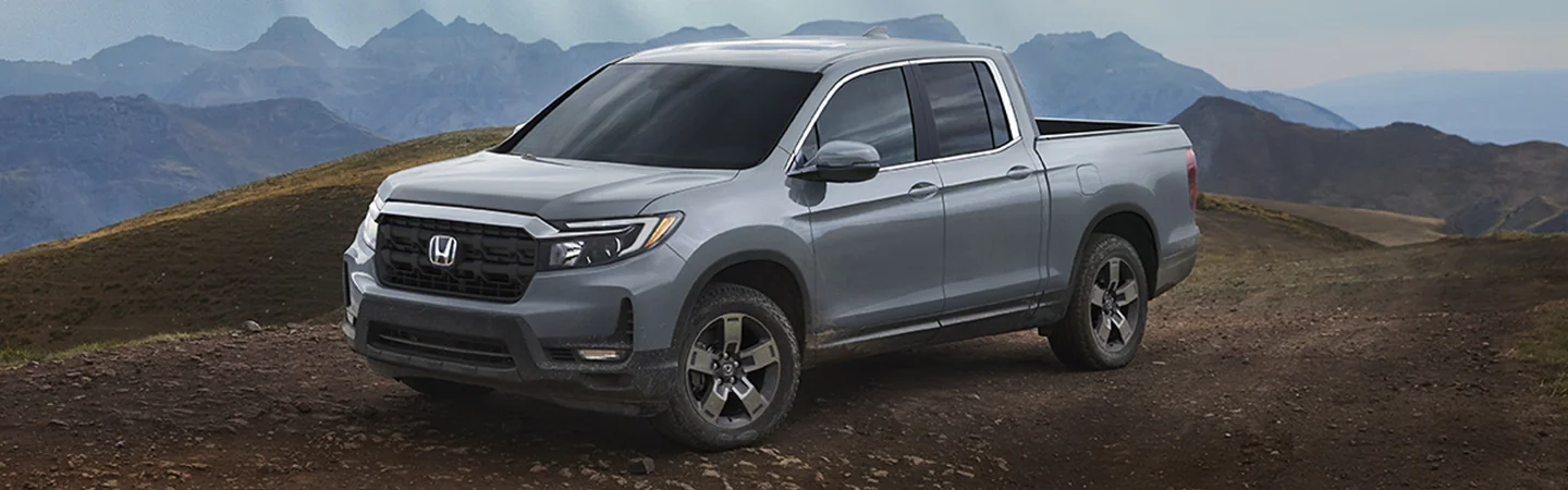 Gray 2025 Honda Ridgeline parked with mountains in the background