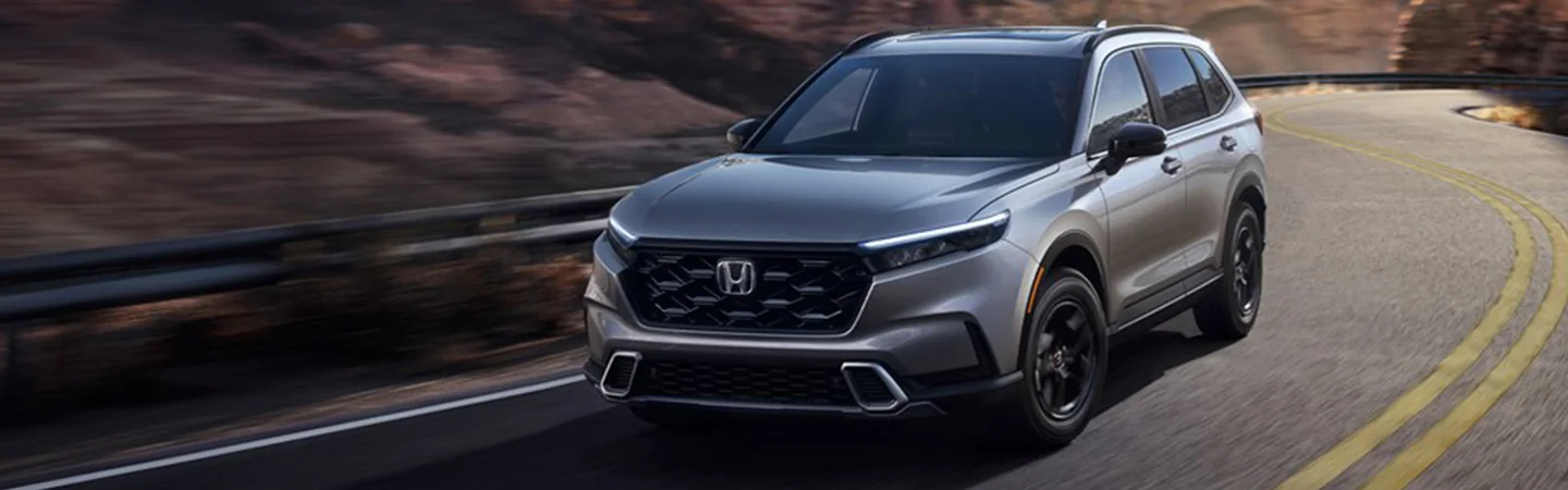 A gray 2025 Honda CR-V driving on a road